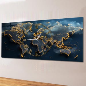 Puede incluir: Un reloj de pared rectangular con un diseño de mapa del mundo. El mapa tiene contornos dorados sobre un fondo azul oscuro. Una esfera de reloj dorada con números romanos se encuentra sobre el mapa. Las manecillas del reloj son blancas.