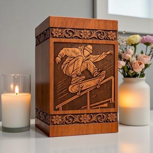 Handcrafted wooden urn box with detailed skateboard engraved design, featuring floral carved borders, polished brown finish, and secure lid, displayed on a white shelf beside a candle and flowers, perfect as a personalized memorial keepsake for ashes.