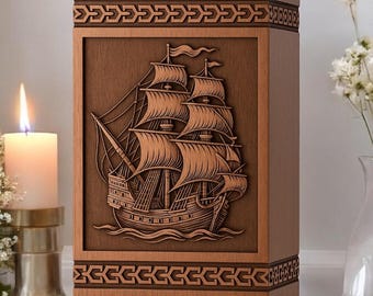 May include: A rectangular wooden cremation urn featuring a detailed relief carving of a sailing ship on the front panel. The top and bottom sections of the urn are decorated with a geometric border pattern in a darker brown wood finish.
