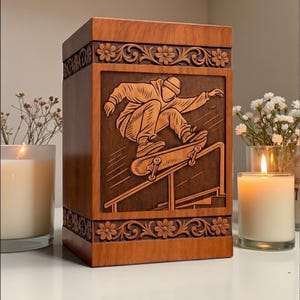Personalized wooden cremation urn box with skateboard artwork engraving, handmade from premium wood, decorative floral carving, smooth finish, and elegant memorial display with candle and flowers for sympathy gift.