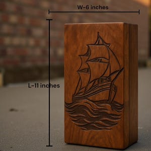 High-quality wooden ashes urn box featuring a classic sailing ship engraving that symbolizes a peaceful final voyage. The warm wood tone and expert craftsmanship make it perfect for ceremonies or home display. Personalization service offered for engraved names and dates.