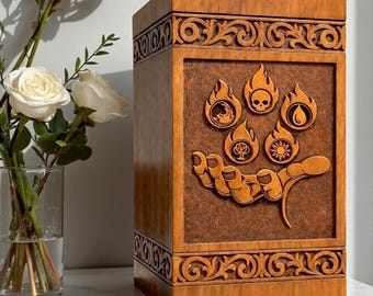 May include: A rectangular wooden urn with a medium brown finish, featuring intricate carved scrollwork borders at the top and bottom. The center panel displays a relief carving of an open hand cradling five circular flame icons with symbols.