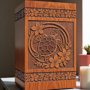 May include: A rectangular wooden cremation urn featuring a carved sea turtle surrounded by tropical flowers. The box has a smooth finish with decorative floral borders carved into the top and bottom sections, showcasing natural wood grain patterns.