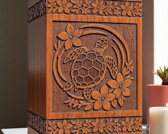 May include: A rectangular wooden cremation urn featuring a carved sea turtle surrounded by tropical flowers. The box has a smooth finish with decorative floral borders carved into the top and bottom sections, showcasing natural wood grain patterns.