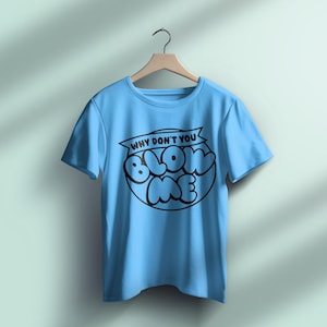 Pu&ograve; includere: T-shirt azzurra con la scritta nera "WHY DON'T YOU BLOW ME" in un cerchio. La maglietta &egrave; appesa a una gruccia di legno su uno sfondo azzurro chiaro.