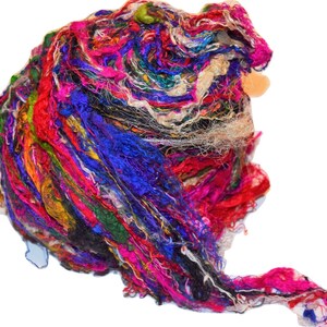 May include: A colorful bundle of silk ribbon scraps in shades of pink, blue, green, purple, and white. The ribbon is perfect for crafting and creating unique projects.