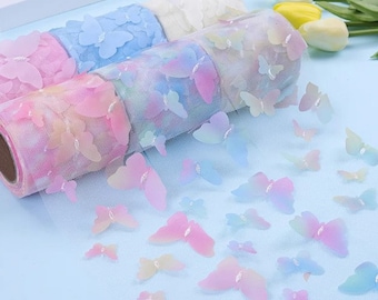 May include: Rolls of iridescent blue, pink, and white tulle ribbon with butterfly cutouts. The ribbon is rolled up and there are loose butterflies scattered on a light blue surface.