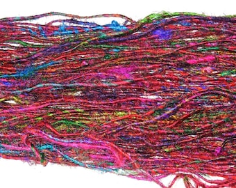 May include: A close-up of a bundle of colorful silk yarn. The yarn is a mix of red, pink, green, blue, and purple. The yarn is soft and delicate, and it would be perfect for knitting or crocheting.