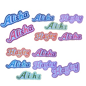 May include: A selection of embroidered name patches, spelling "Alisha" and "Hayley", in a range of colours. The patches use a cursive font with light blue, pink, orange, and green outlines. The patches are set against a white backdrop.