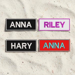 May include: Four rectangular name patches with embroidered text. Two patches have black backgrounds with white text reading "ANNA" and "HARY". The other two patches have white and red backgrounds with purple and turquoise text reading "RILEY" and "ANNA".