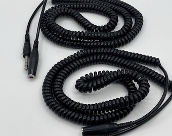May include: Two black coiled audio cables with 1/4 inch and 1/8 inch male and female connectors. The cables are made of a flexible, rubber-like material. The cables are designed for audio equipment.