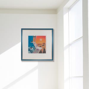 May include: A framed art print with a blue border. The artwork depicts a surreal landscape with a staircase leading to an archway under a sunset. The color palette includes blues, oranges, and yellows, creating a vibrant and dreamlike scene.