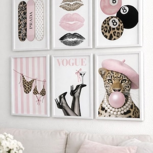 Könnte beinhalten: Eine Sammlung gerahmter Kunstdrucke mit Modethema. Die Drucke zeigen Lippen, Leopardenmuster, ein Vogue-Magazin-Cover, einen Leoparden mit rosa Barett und einen Bikini. Die Farbpalette ist hauptsächlich rosa, schwarz und weiß.