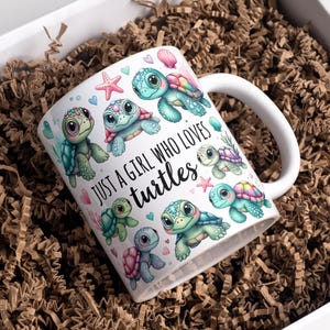 May include: White ceramic mug featuring colorful cartoon turtles and the text "JUST A GIRL WHO LOVES turtles." The mug is decorated with starfish and hearts. The mug is inside a white box filled with brown packing material.