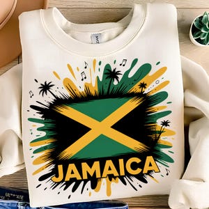 Può includere: Felpa color crema con una grafica della bandiera giamaicana in nero, verde e giallo. La parola "JAMAICA" è stampata in giallo. Il design include anche palme e note musicali.