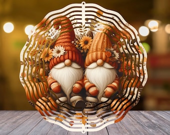 Peut inclure: Découpe en bois décorative représentant deux gnomes avec des barbes blanches, portant des chapeaux et des tenues orange et rouges. Les gnomes sont entourés de feuillage d'automne et de fleurs, avec un bord festonné.