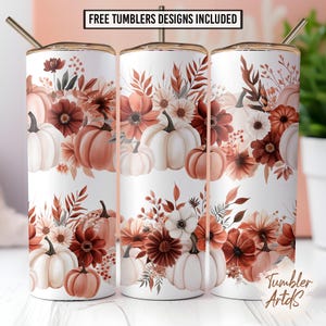 Puede incluir: Tres vasos blancos con tapas y pajitas doradas, con un diseño temático de otoño. El diseño incluye calabazas blancas y naranjas, flores y hojas en tonos marrones y naranjas. El texto en la parte superior dice "FREE TUMBLERS DESIGNS INCLUDED".