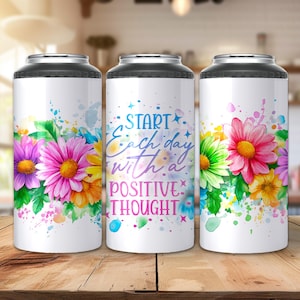 Puede incluir: Tres enfriadores de latas blancos con tapas negras, cada uno adornado con coloridas flores de acuarela. El enfriador central presenta el texto "Start each day with a positive thought". Las flores incluyen rosa, morado, amarillo y naranja.