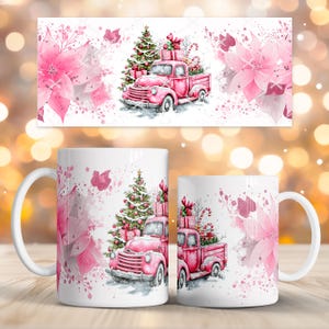 Puede incluir: Taza de cerámica blanca con un diseño de camión navideño rosa que transporta regalos y un árbol de Navidad. El diseño incluye flores de pascua rosas y purpurina, creando un tema festivo. La taza tiene un asa blanca.