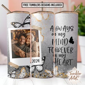 May include: A personalized tumbler with a photo, butterflies, and the text "Always on my mind, forever in my heart." The design includes gold accents and the year 2024. The tumbler has a silver background and a straw.