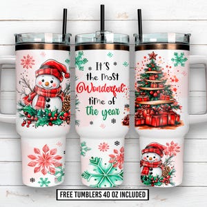 Puede incluir: Vasos blancos de 1,18 litros con diseños navideños. Uno presenta un muñeco de nieve, otro un árbol de Navidad y el tercero tiene el texto "It's the Most Wonderful Time of the Year". Cada vaso tiene una pajita negra y un borde color cobre.