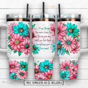 Puede incluir: Tres vasos blancos de 1183 ml con diseños florales en rosa y turquesa. Cada vaso tiene una pajita negra y una banda color cobre en la parte superior. Un vaso tiene el texto "Keep Going" y "Everything you've overcome!"