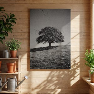 Puede incluir: Impresión artística en lienzo en blanco y negro que representa un gran árbol en una colina cubierta de hierba bajo un cielo nublado. La obra de arte tiene un aspecto texturizado y está enmarcada. Se ven pájaros volando en el cielo. El arte se exhibe en una habitación con paneles de madera.