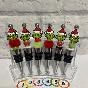 Merry Christmas with these Wine Toppers that are handcrafted with silicone and fluffy beads and topped off with the Christmas Grinch