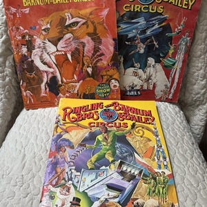 Peut inclure: Trois programmes souvenirs du cirque Ringling Bros. and Barnum & Bailey. Celui en haut à gauche présente un tigre, celui en haut à droite montre des numéros de cirque sur le thème de l'espace, et le programme du bas affiche un artiste en vert.