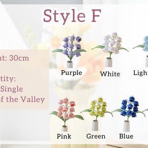 以下が含まれることがあります： 紫、白、水色、ピンク、緑、青、黄色の人工スズランの花のディスプレイ。各花は小さな白い花瓶に入っています。花の高さは30cmです。