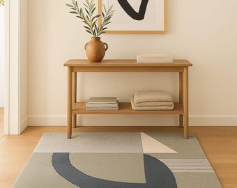 May include: Interior shot with a wooden console table, framed abstract art, and a vase with greenery. A geometric rug in grey, blue, and cream tones is on the floor. The table is approximately 100 cm in height.