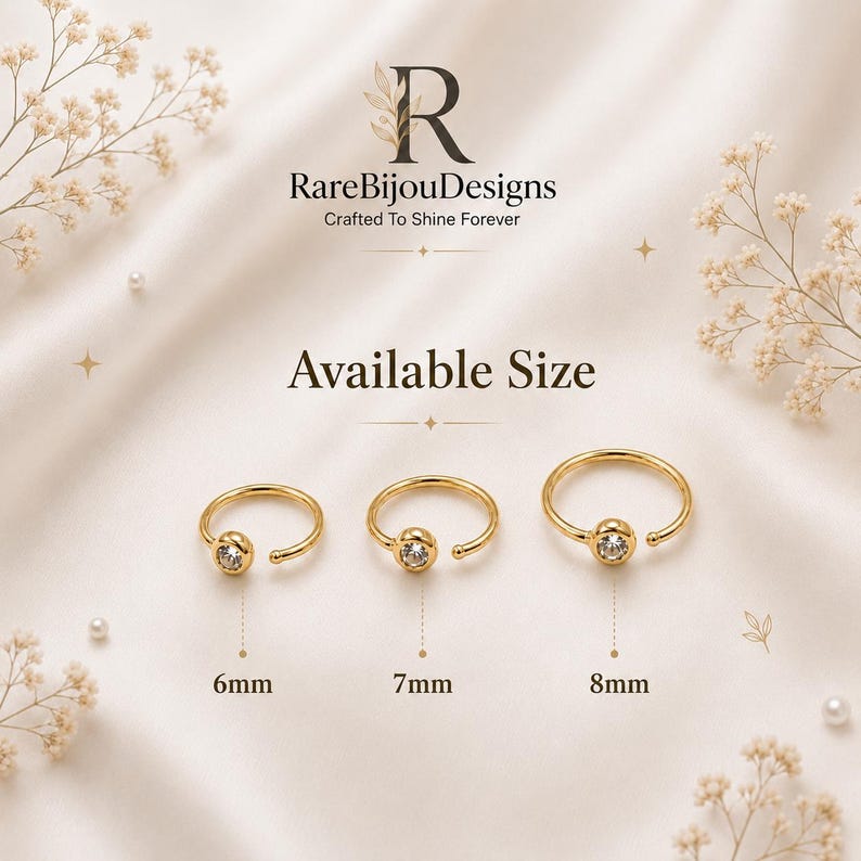 May include: Three gold-colored nose rings with a clear gem in the center, displayed on a cream-colored surface. Sizes are 6mm, 7mm, and 8mm. The brand name "RareBijouDesigns" is visible.