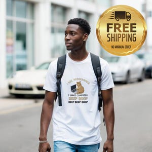 May include: White t-shirt featuring the text "I ARE PROGRAMMER" and a graphic of a cat and laptop. Below the graphic are the words "I MAKE COMPUTER BEEP BOOP BEEP BEEP BOOP". A gold emblem with "FREE SHIPPING" and "NO MINIMUM ORDER" is also visible.