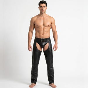 Puede incluir: Chaps de cuero negro con diseño de cintura alta, cierre de cinturón frontal y hebilla de metal plateado. La prenda presenta una construcción de entrepierna abierta y piernas largas que llegan hasta los tobillos, con una textura lisa.