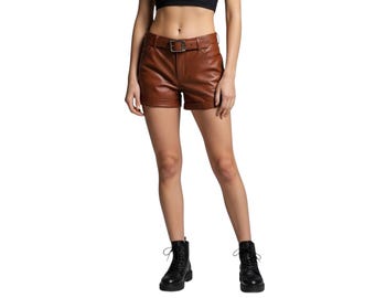 Op de afbeelding: Bruine leren shorts met bijpassende riem en gesp. De shorts hebben een klassiek design en worden gecombineerd met zwarte combat boots. De shorts zijn warmbruin.