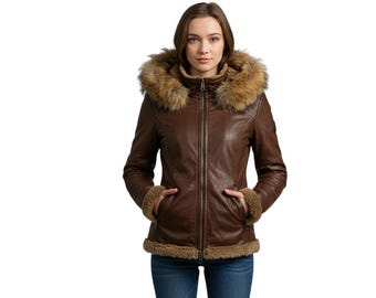 Puede incluir: Chaqueta de cuero marrón con capucha y puños con ribete de piel. La chaqueta tiene cierre de cremallera y bolsillos. La modelo lleva vaqueros azules. La chaqueta está diseñada para el frío.