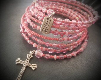 Bead soup memory wire beaded cuff bracelet, with silver charms. Coral seed beads and various sized and pink colored glass and acrylic beads.