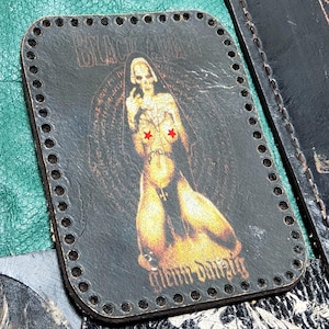 May include: Black leather patch with a skeleton figure illustration. The image features a skeleton with red star-shaped coverings over the chest. The text "BLACK ACID" is at the top, and "glenn danzig" is at the bottom. The patch has a stitched border.