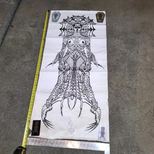 May include: A black and white illustration of a stylized figure with intricate details, resembling a gothic or fantasy design. The artwork is on a white background, with a measuring tape alongside it. Small coffin-shaped images are also present.