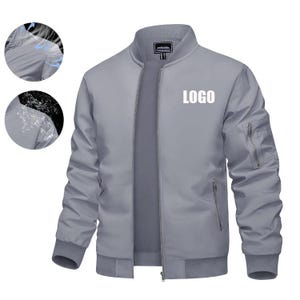 May include: A grey bomber jacket with a full-length zip, two side pockets, and a chest pocket. The jacket has a ribbed collar, cuffs, and hem. The word "LOGO" is printed in white on the chest.