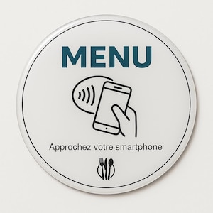 Könnte beinhalten: Ein weißes, rundes Schild mit schwarzem Rand. Das Wort "MENU" steht in türkisfarbenen Großbuchstaben oben. Darunter eine Grafik, die ein Smartphone und eine Hand darstellt, mit dem Text "Approchez votre smartphone" und einem Bestecksymbol.