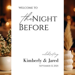 May include: A white wedding welcome sign with black text that reads "WELCOME TO the NIGHT BEFORE" and "celebrating Kimberly & Jared SEPTEMBER 12, 2025". The sign is on a wooden table with floral arrangements.