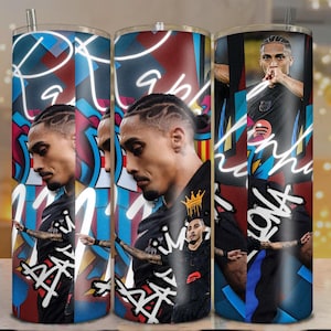 May include: A set of three stainless steel tumblers featuring a portrait of a soccer player. The tumblers have a graffiti-style design with the word "Barcelona" and the player's name. The color scheme includes blue, red, and white.
