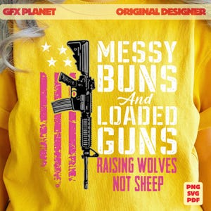 May include: Yellow t-shirt with a graphic design featuring a black rifle, pink stripes, and the text "MESSY BUNS And LOADED GUNS RAISING WOLVES NOT SHEEP". The design includes white stars.