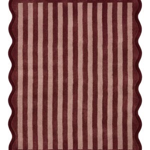 May include: A rectangular rug featuring a pattern of alternating vertical stripes in deep burgundy and soft dusty pink. The rug is finished with a continuous scalloped edge border in the same deep burgundy color, creating a wavy perimeter.