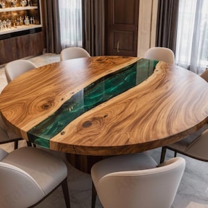 Puede incluir: Una gran mesa de comedor redonda de madera con un río de resina epoxi verde en el centro. La mesa está rodeada por ocho sillas de color crema. La veta de la madera es visible y la mesa tiene un aspecto natural y orgánico. Diámetro aproximado 150 cm.
