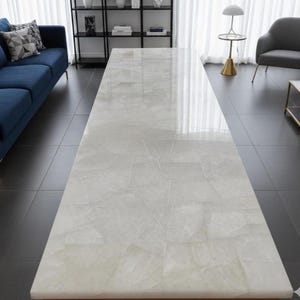 May include: A large, rectangular coffee table with a light-coloured, patterned surface. The table's top has a glossy finish and is supported by a wooden frame. The table is in a modern living room setting.