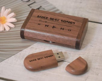 May include: A wooden USB flash drive and matching case. The case and drive are engraved with the text "MIKE BEST SONGS" and music control symbols. The drive is partially inserted into the case, with the cap detached.