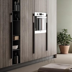 Op de afbeelding: Een moderne keuken met houten kasten en een ingebouwde oven. De kasten hebben een houtnerf afwerking in grijstinten en bruintinten. Een potplant staat in de hoek en een klein vloerkleed ligt op de vloer.