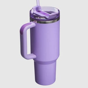 Op de afbeelding: Een lavendelkleurige ge&iuml;soleerde beker met een handvat en een doorzichtig deksel. De beker heeft een bijpassend lavendelkleurig rietje en een zilveren rand. Het handvat is gebogen en aan de zijkant van de beker bevestigd.